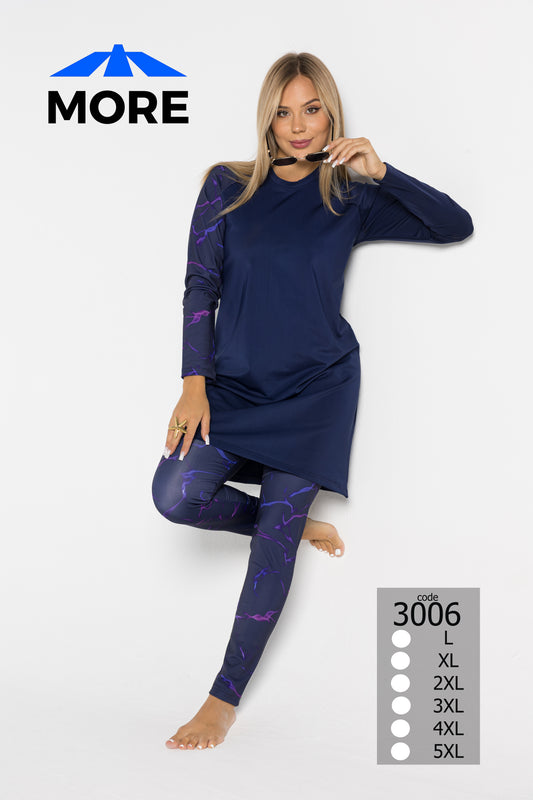 Woman wearing a navy long-sleeve top and leggings with purple patterns, standing against a white background. 'MORE' brand logo is visible.