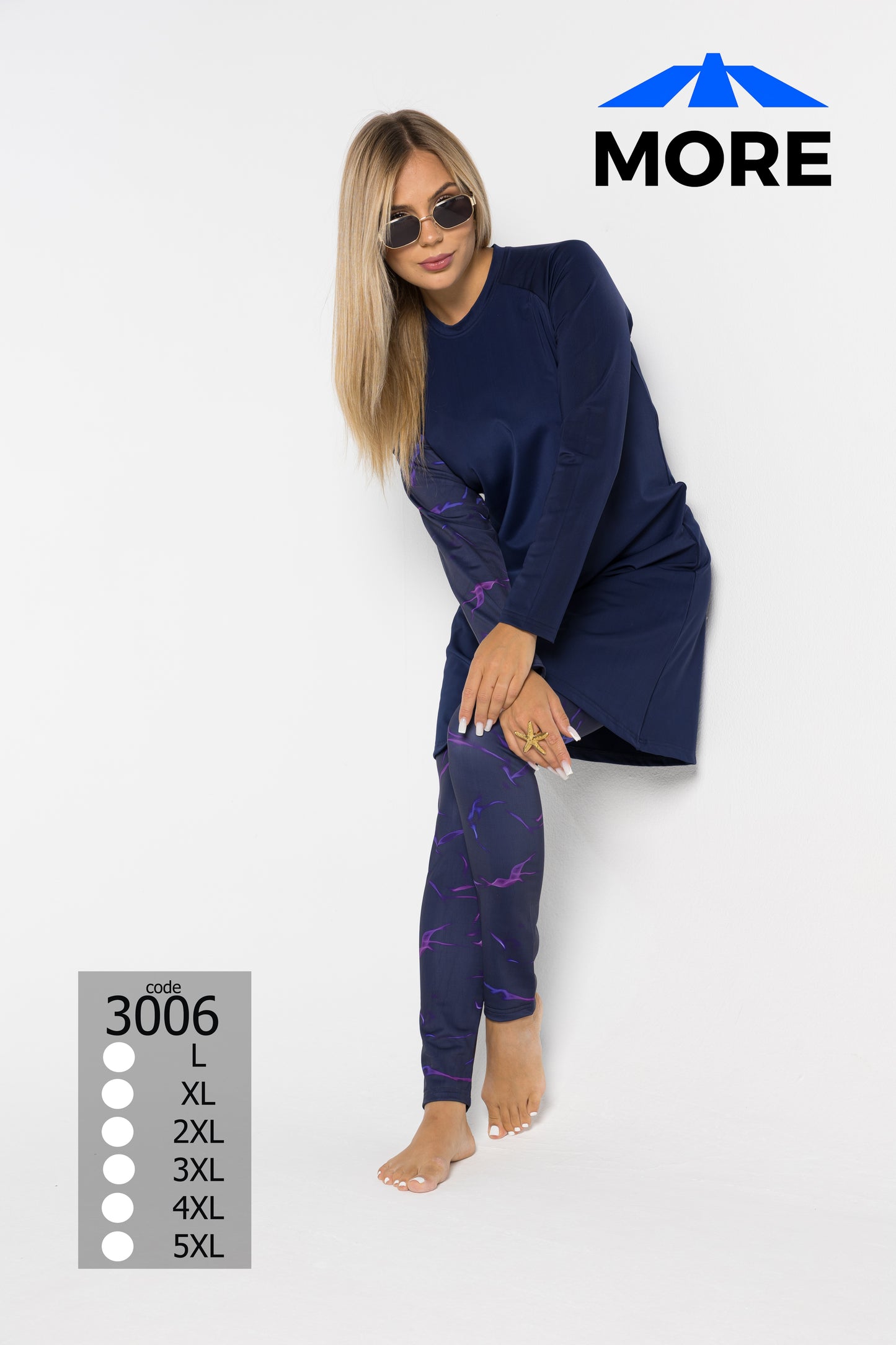 Woman wearing a navy long-sleeve top and patterned leggings on a white background with 'MORE' branding.