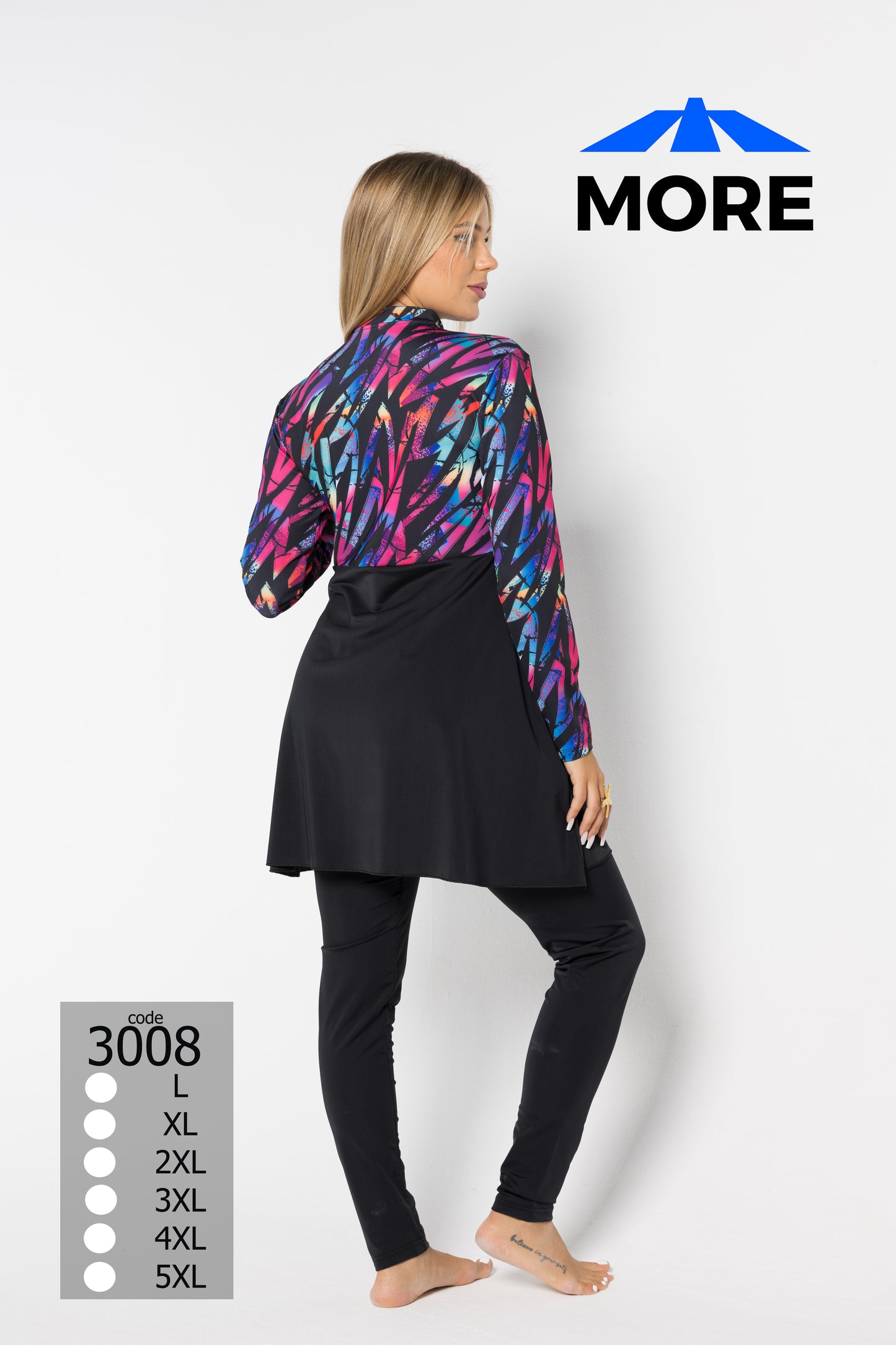 Woman wearing a colorful jacket and black pants with 'MORE' branding on a white background