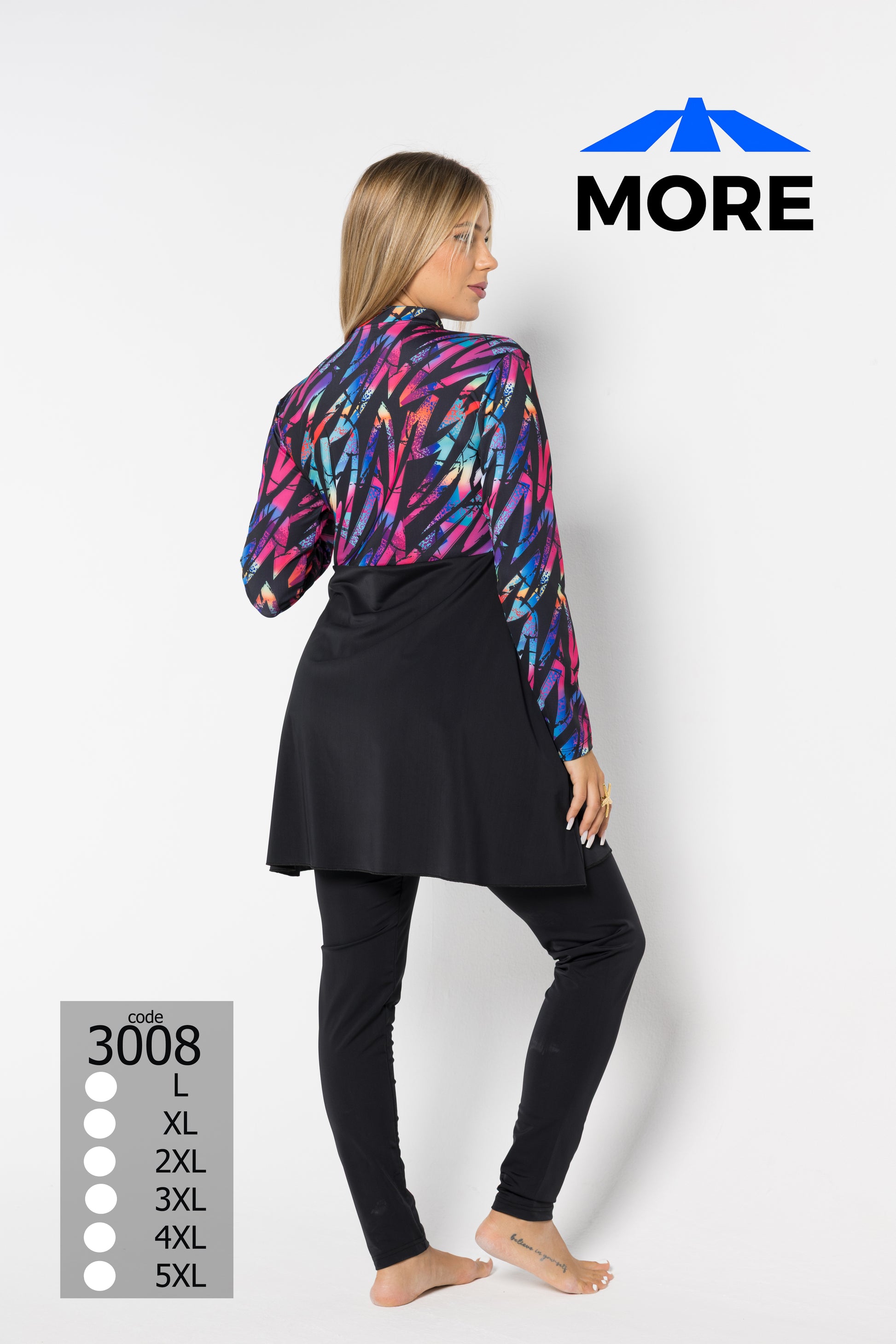 Woman wearing a colorful jacket and black pants with 'MORE' branding on a white background