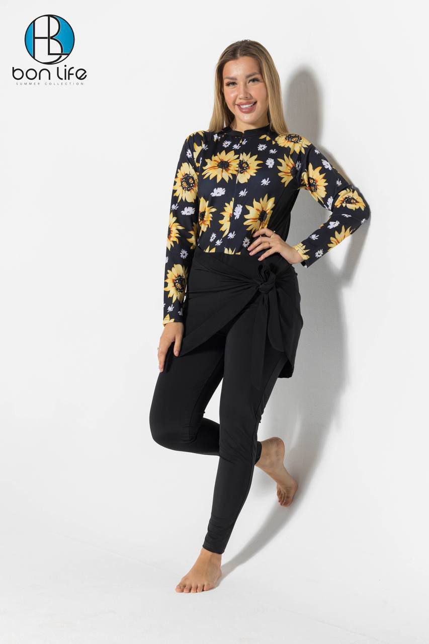Woman wearing a black long-sleeve top with sunflower pattern and black pants on a white background, featuring the brand 'bon life'.