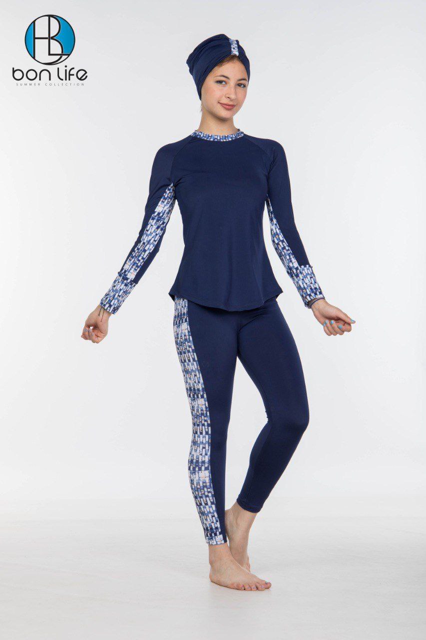 Person wearing a navy blue swimsuit with white floral patterns on a white background, featuring the brand 'bon life'.