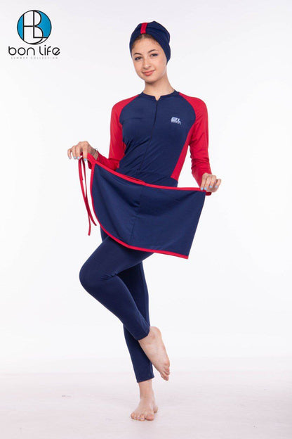 Woman wearing a navy and red swimsuit with a matching headscarf, standing against a white background.